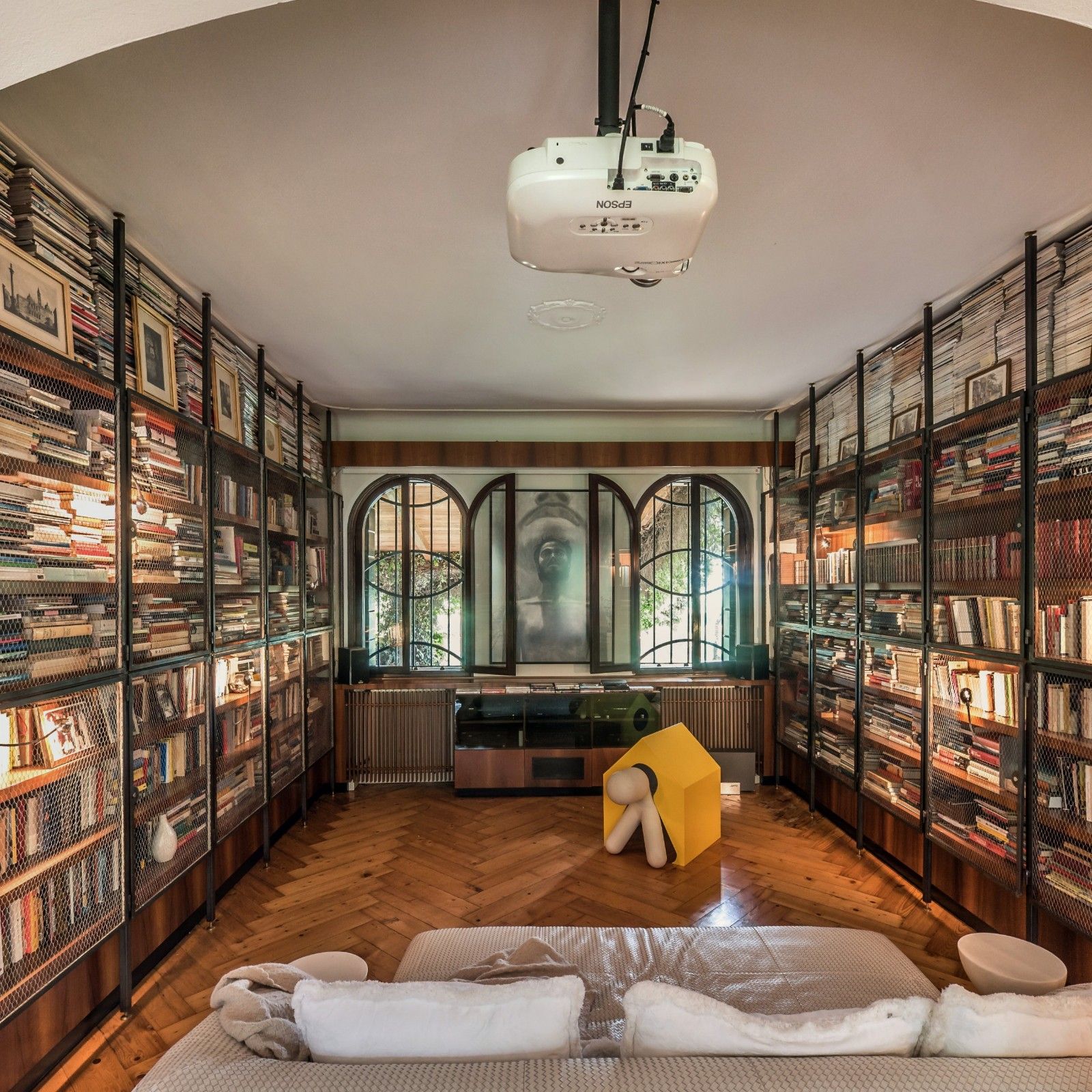 A room lined with bookshelves under a wide arch