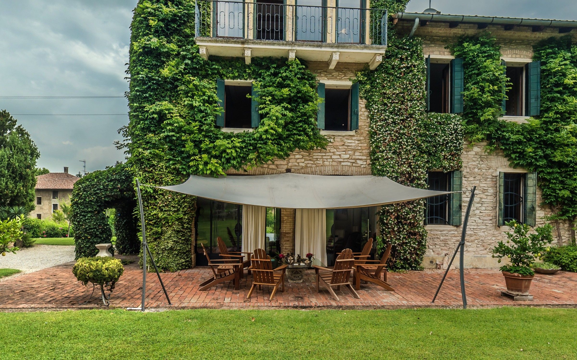 The garden front of Villa La Quadrata, its stone walls covered in ivy